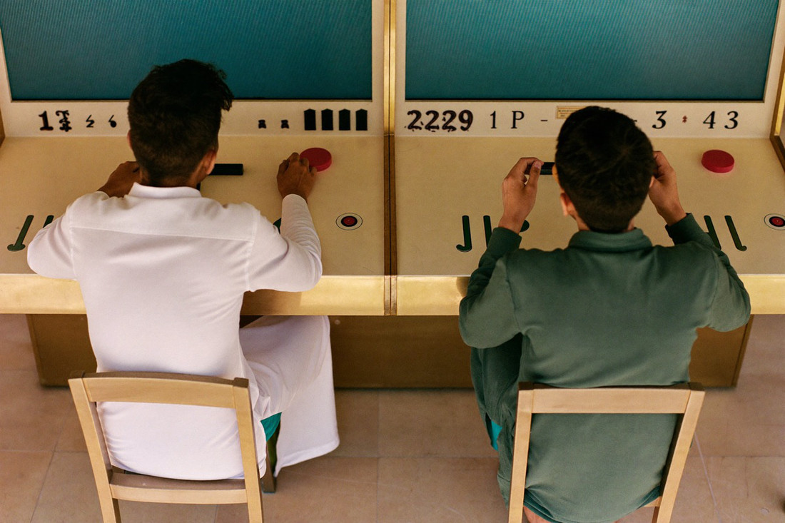 A row of wide arcade cannon cabinets with glowing blue-green table screens