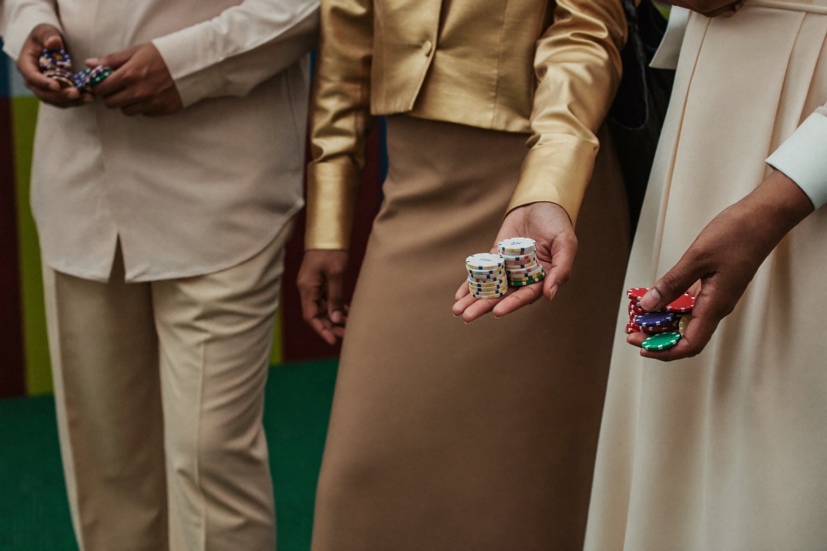 A croupier's hands stacking coloured chips into towers on green baize