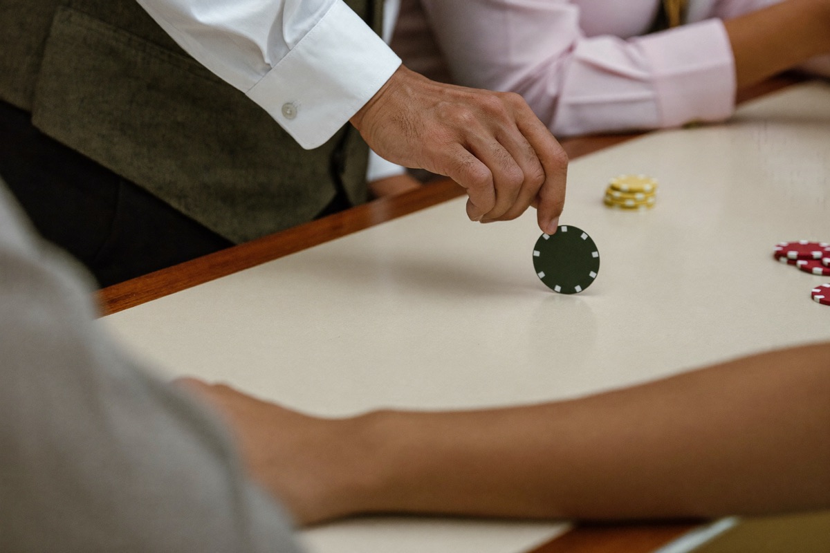 A host sliding a single plain chip across a counter to a guest's hand
