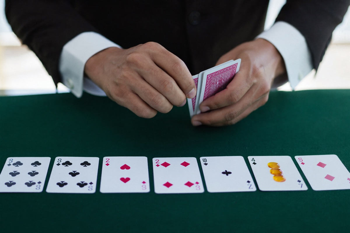 A dealer in a waistcoat mid-deal under a bright studio light