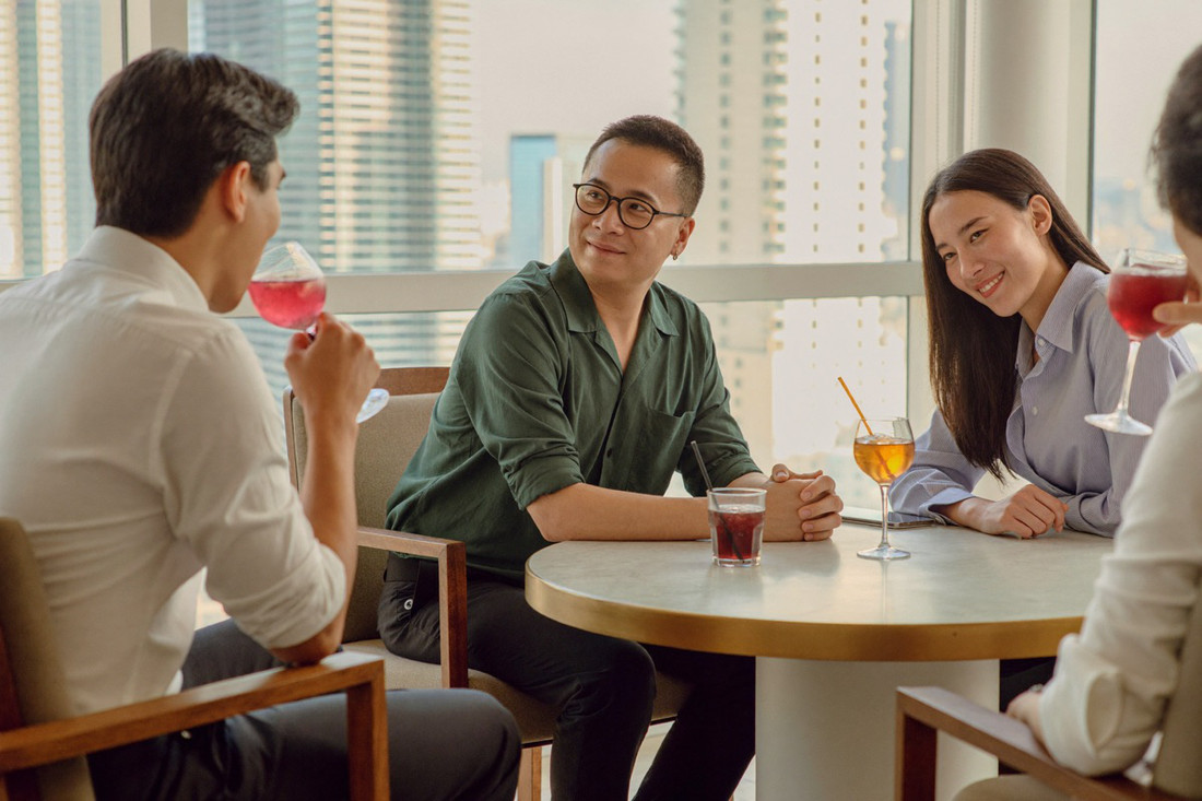 Four friends around a low table in a Kuala Lumpur hotel lounge